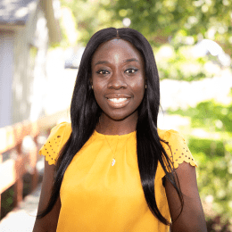 2023年，阿曼达·阿瓦迪——一位身穿黄色衣服、面带微笑的黑人女性——在霍利奥克山校园里