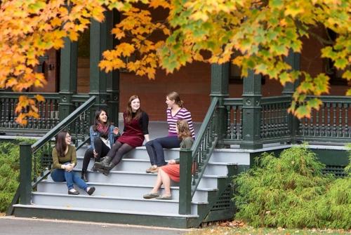A group of Mount Holyoke College students sitting on some steps talking